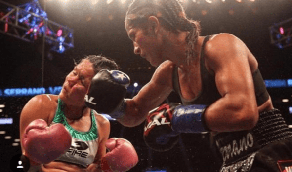 A woman in the middle of a boxing match.