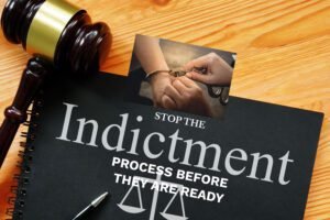 Stop the indictment sign showing a person in court getting the handcuff's removed to be released.